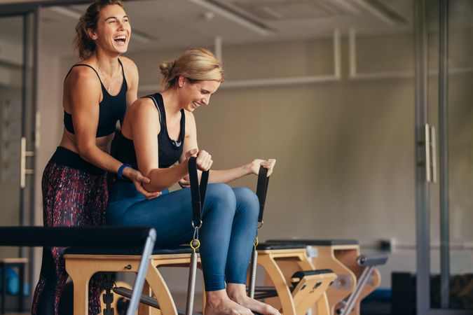 Smiling woman at the gym doing pilates training with her trainer