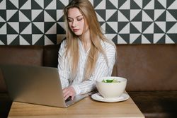 Young woman using laptop in cafe