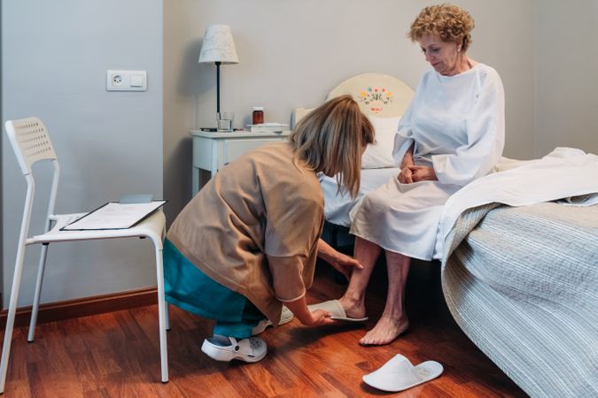 Carer wearing slippers to older patient