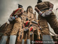 Back view of Indian soldiers standing with respect against The Secretariat Building in New Delhi, India 0yGv14