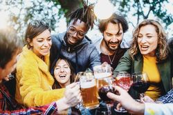 Group of people laughing and talking together at pub brewery