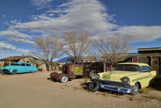 Vintage cars and trucks parked outside wooden lodges