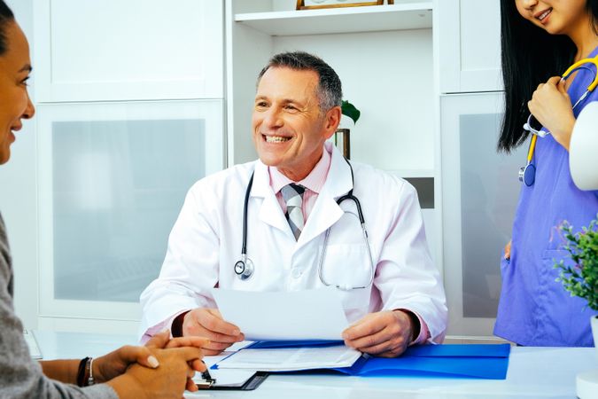 Doctor discussing file with patient in office