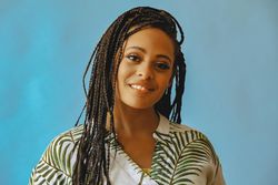 Portrait of relaxed content female with long braided hair in printed leaf shirt