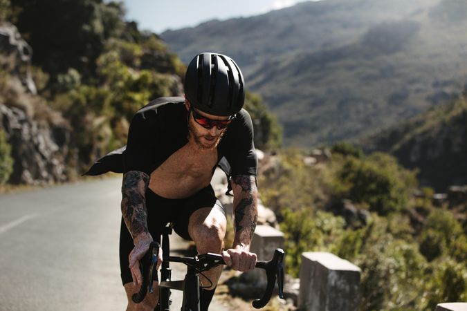 Man climbing up the mountain road on a bicycle
