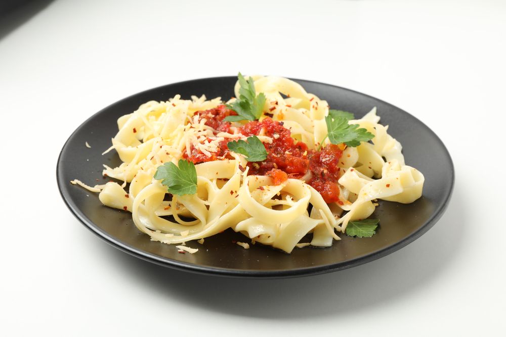 Plate with tasty pasta isolated on plain background