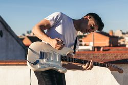 man playing electric guitar enjoying