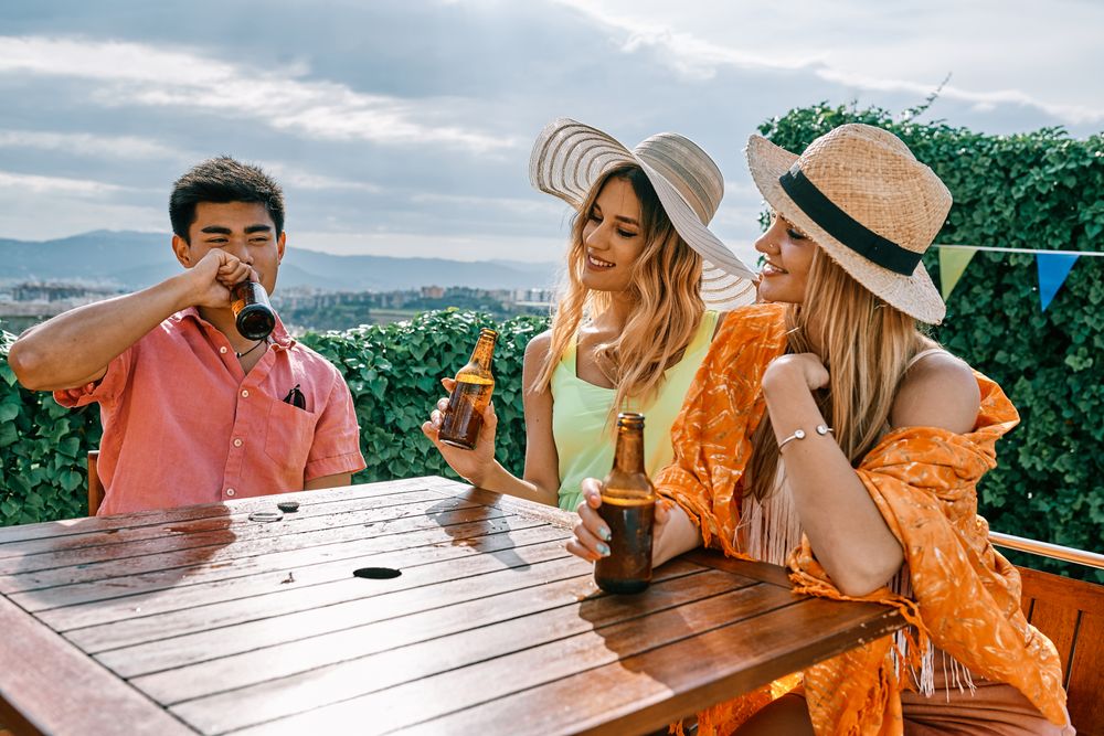 a group of young people having a good time in a summer day and cheering with beer