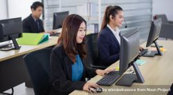 Young Asian business call center employees with headset sitting in office 56Kpj4