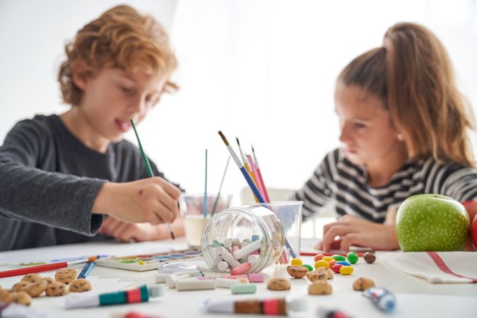 Children painting at messy table