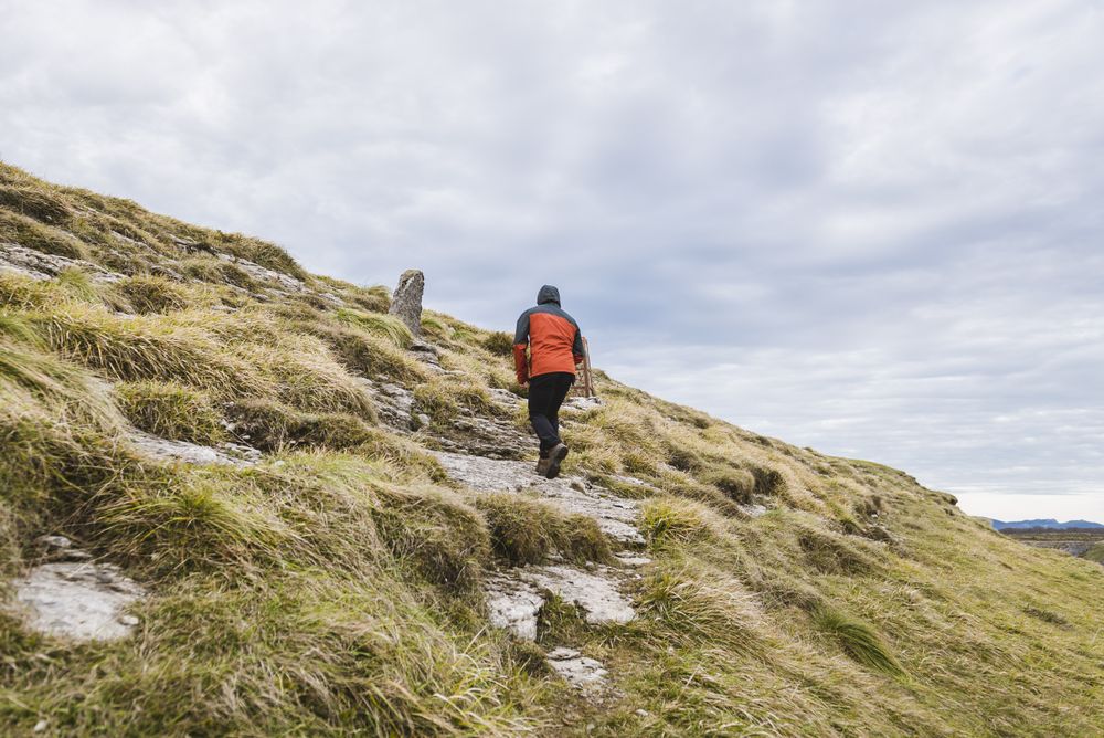 Man walking on hill near valley