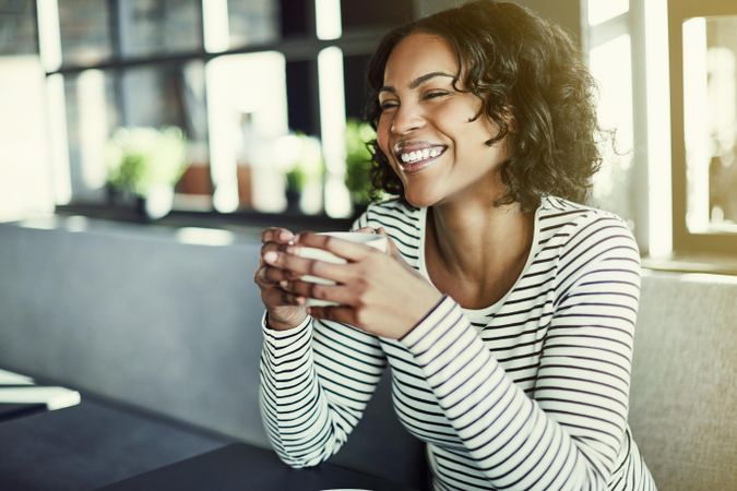 Smiling woman with a nice cup of coffee in hand