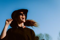 Dreaming stylish woman in sunglasses and hat