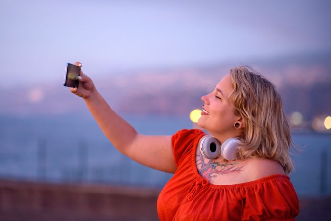 Positive woman taking selfie on smartphone
