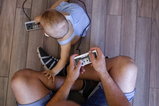 Anonymous father and baby playing video games