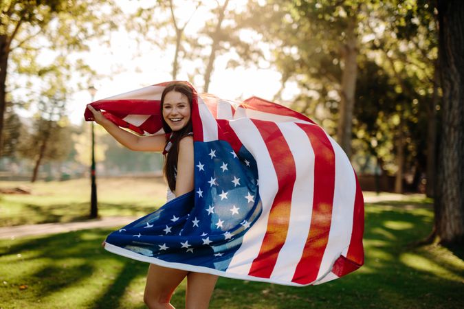 Patriotic woman with American flag in the park