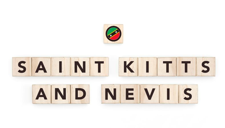 Wooden blocks bearing the name and flag of Saint Kitts And Nevis. Nevisian and Caribbean Culture, national identity, travel, and geography in a copy space design.