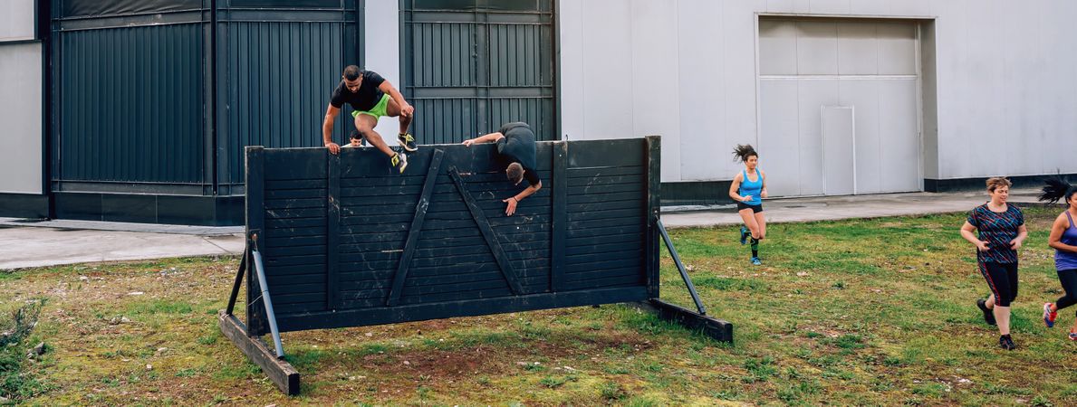 Participants in obstacle course running and climbing wall