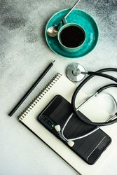 Top view of coffee cup with phone and notepad