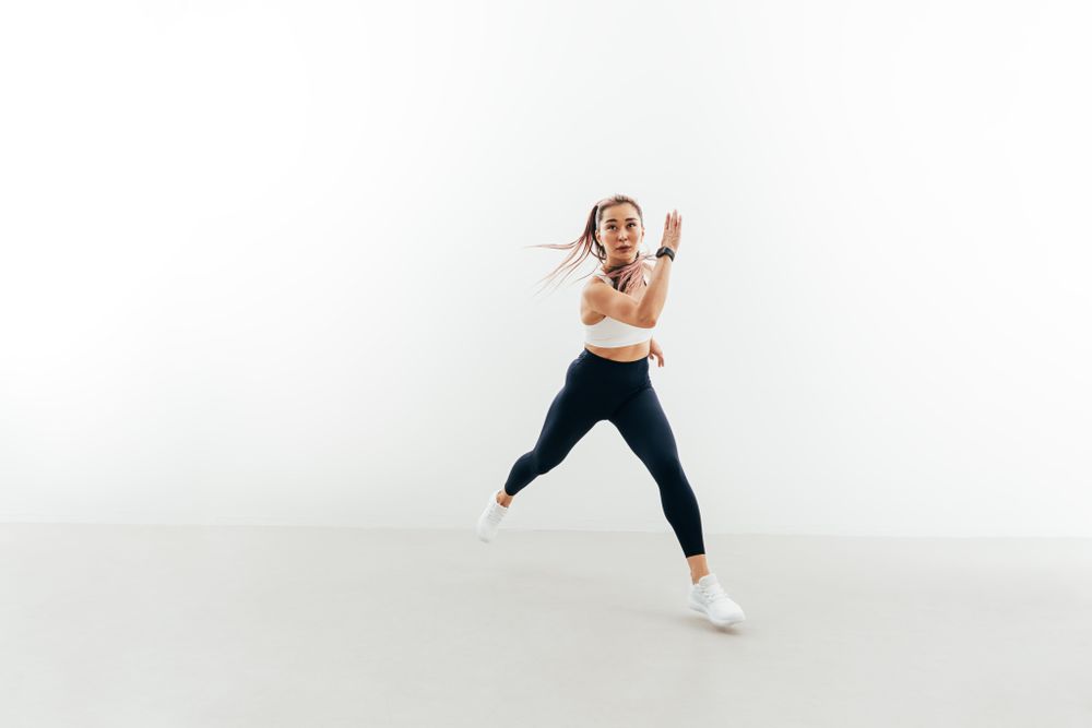 Sporty woman running forward indoors