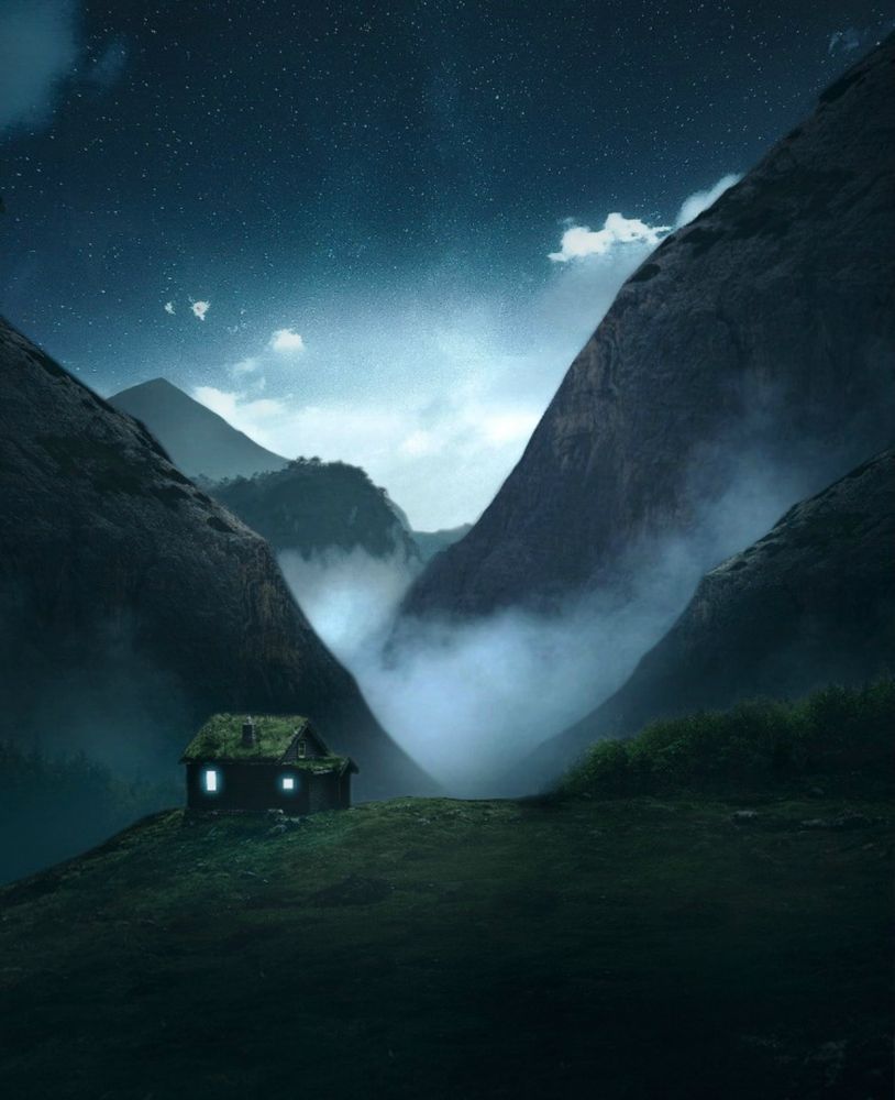 Silhouette of house on green grass field near mountain at night