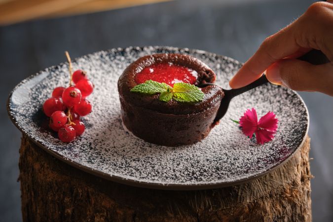 Crop person eating yummy lava cake