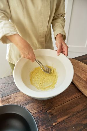 Crop woman mixing mustard sauce in bowl