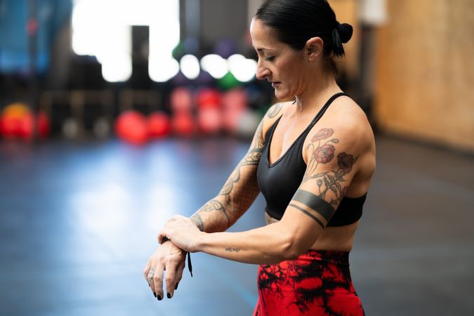 Muscular woman adjusting band on arm