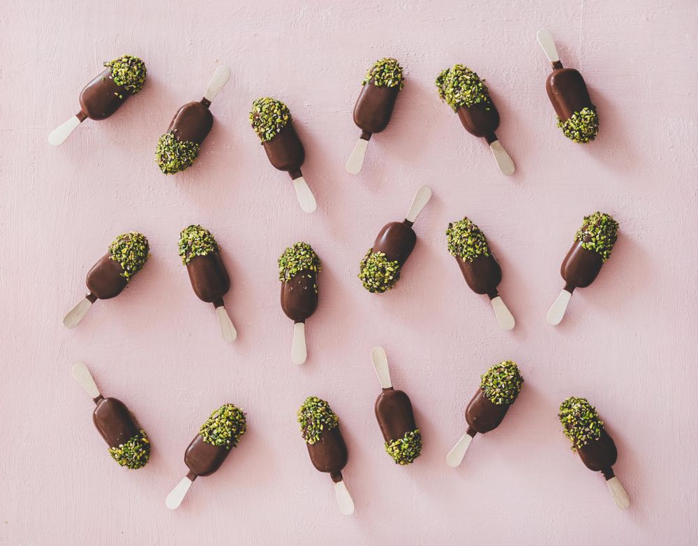 Ice cream chocolate pistachio popsicles, pink background