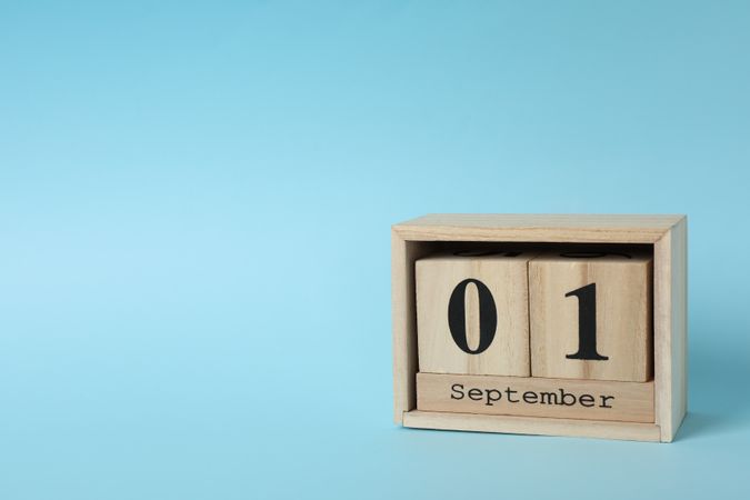 Wooden calendar with date September 1 on blue background, space for text