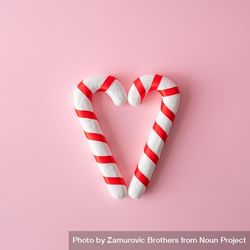 Candy canes in heart shape on pink background 4Zjwr4