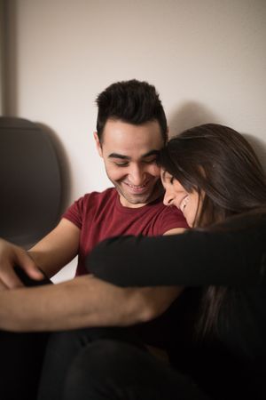 Couple sitting near fireplace on floor