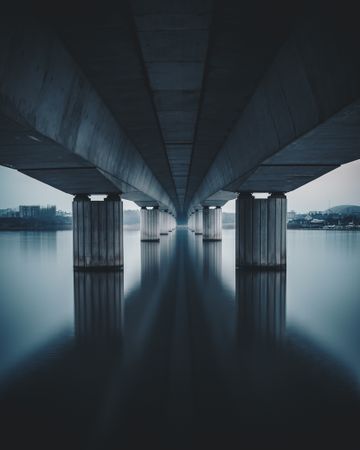 Sea under gray concrete bridge