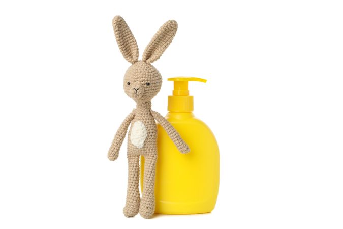 Bottle for soap and bunny doll isolated on light background