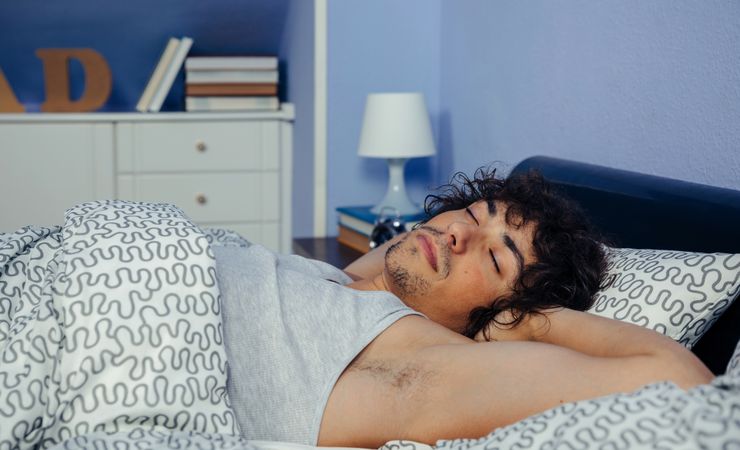 Man sleeping comfortably in bed at home