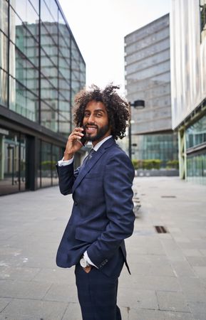 Curly man smiling at street