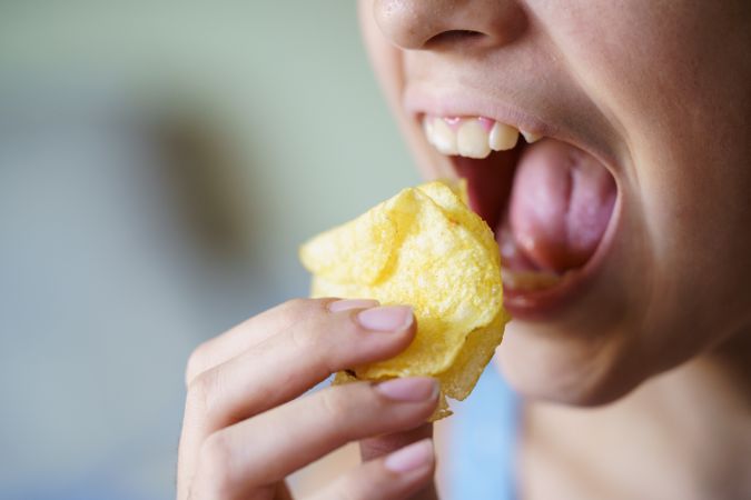 Girl biting into potato chips