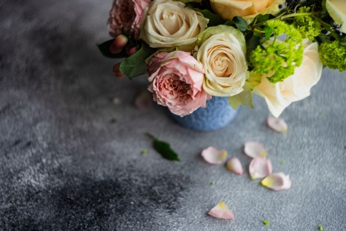 Top view of vase of pastel roses in grey shoot