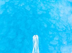 Top down view of a jet ski traveling over a blue water.