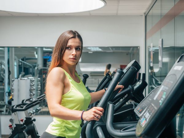 Young woman exercising on modern machine