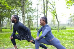 Two friends stretching during the spring morning.