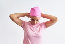 a woman suffering from cancer wearing a pink scarf