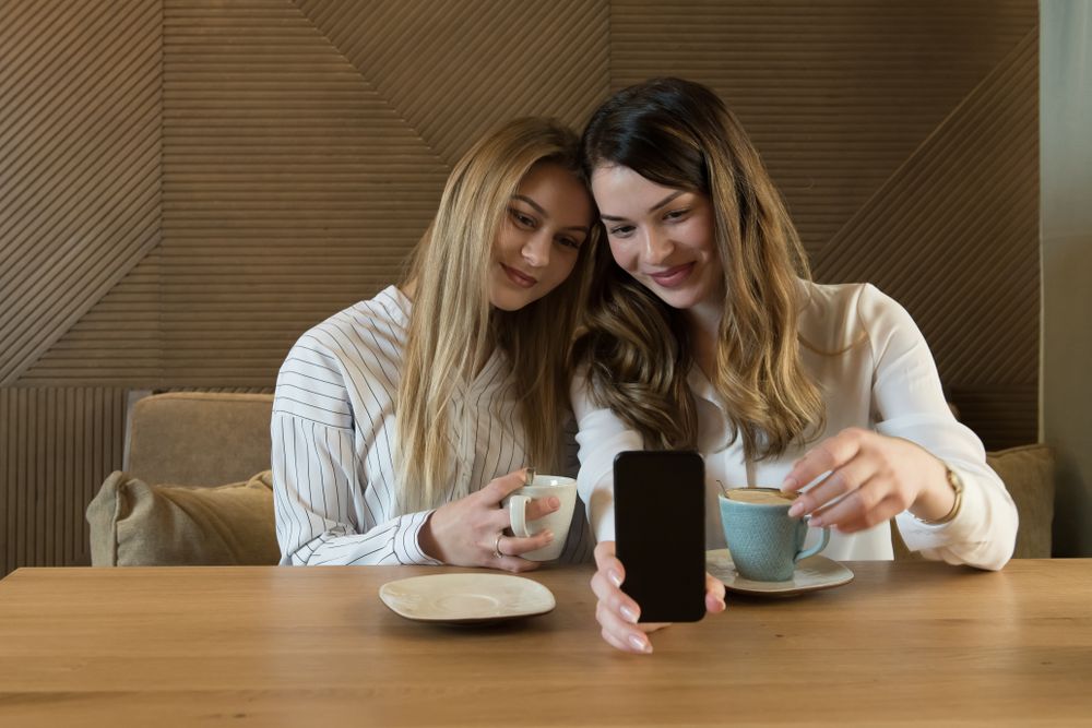Young women taking selfie in cafe