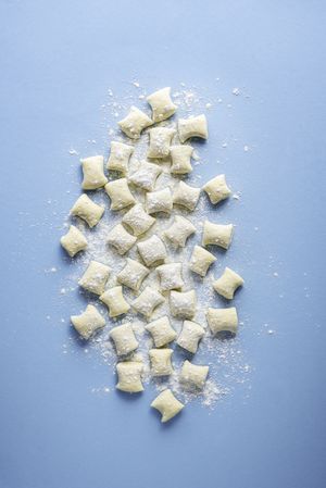 Uncooked gnocchi pile in flour