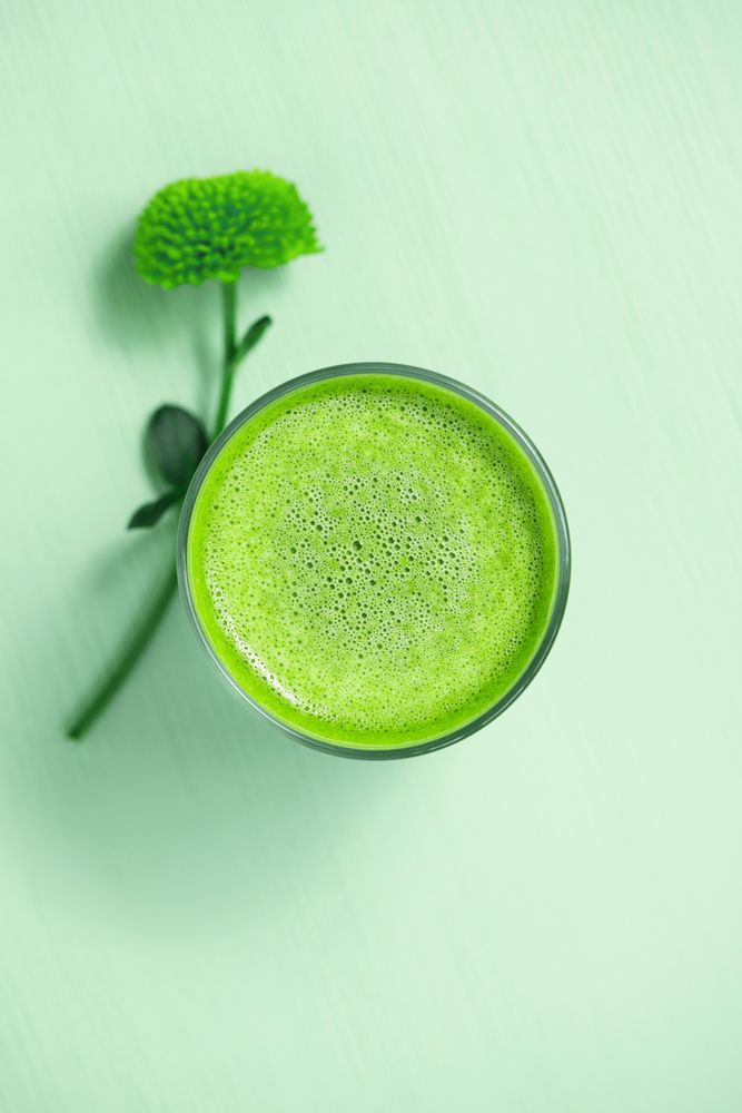 Top view of green tea on green table with flower