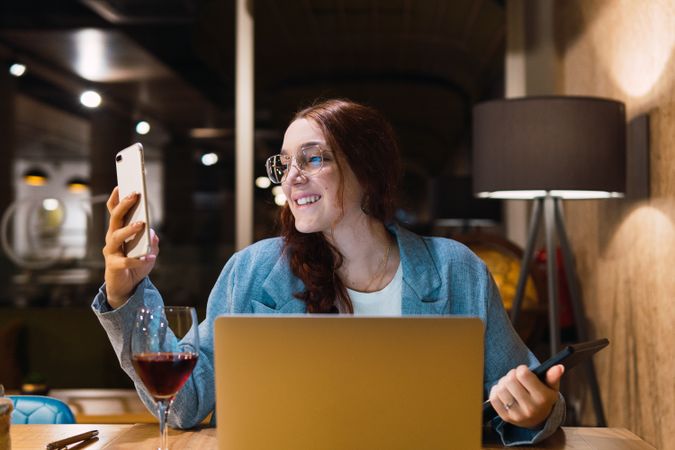 Focused happy female freelancer working in restaurant