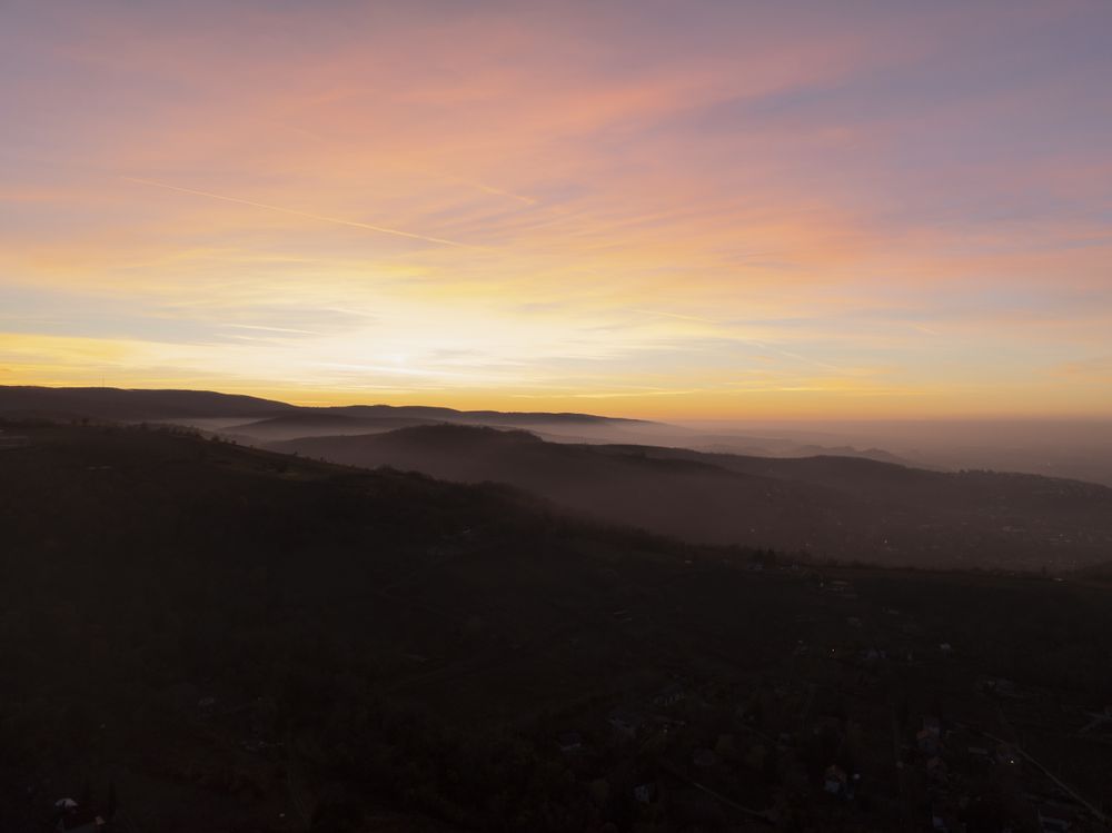 Vibrant Sunset Over Misty Valleys and Distant Mountains.