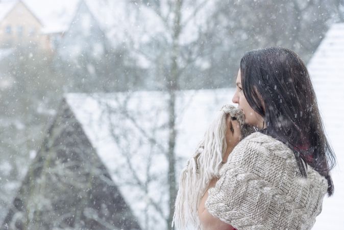 Woman squeezes her shawl enjoying the snow