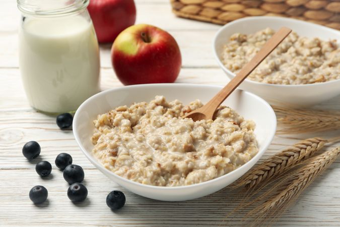 Composition with oatmeal porridge on blank wooden background. Cooking breakfast