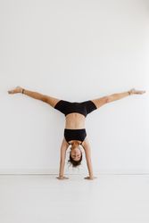 Sportive woman performing yoga pose in room